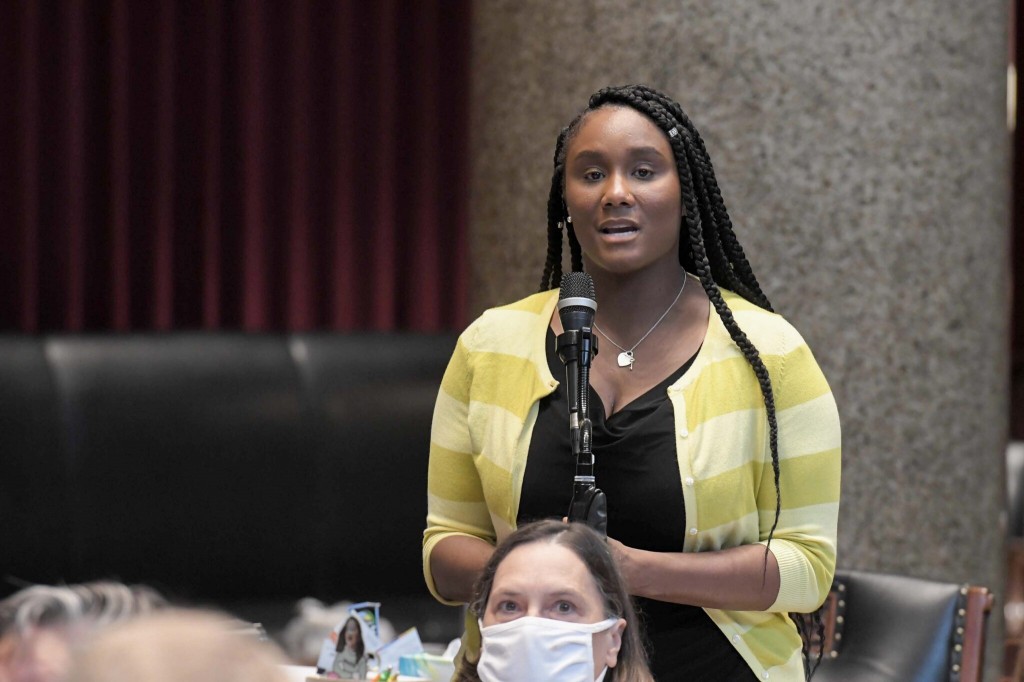 State Rep. Raychel Proudie, D-Ferguson speaks at a microphone during a meeting.