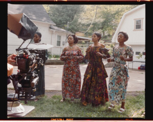 Three members of the Salvation Choir perform while the documentary crew films.