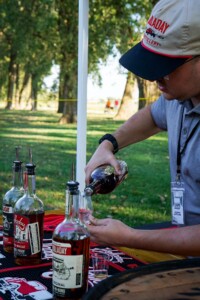 Holladay Distilling volunteer pouring a sample of bourbon