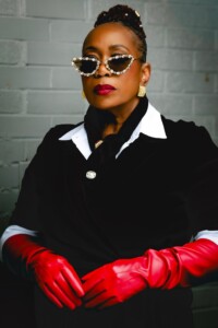 Bosede Iyewarun stuns in red leather gloves and pointed, pearl-studded sunglasses.